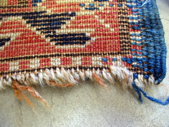 This fringe was cut shorter by the client, but the knots of the rug are now sliding away.