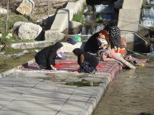 Rugs being washed near a river