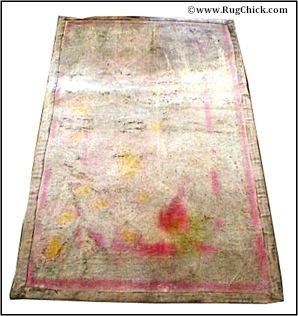 Back of tufted rug – stencil ink bled into backing material.