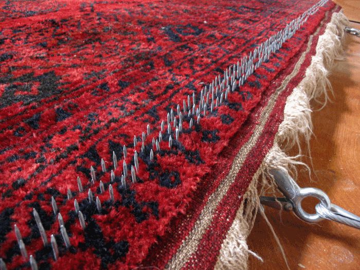 Aggressively trying to "undo" weaving flaws that made the rug buckle.