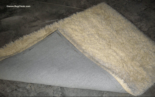 Wool shag rug is yellowing from latex backing and age.