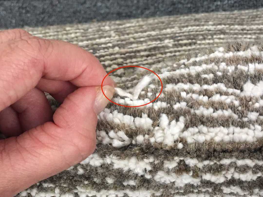 Pulling a fiber from a rug